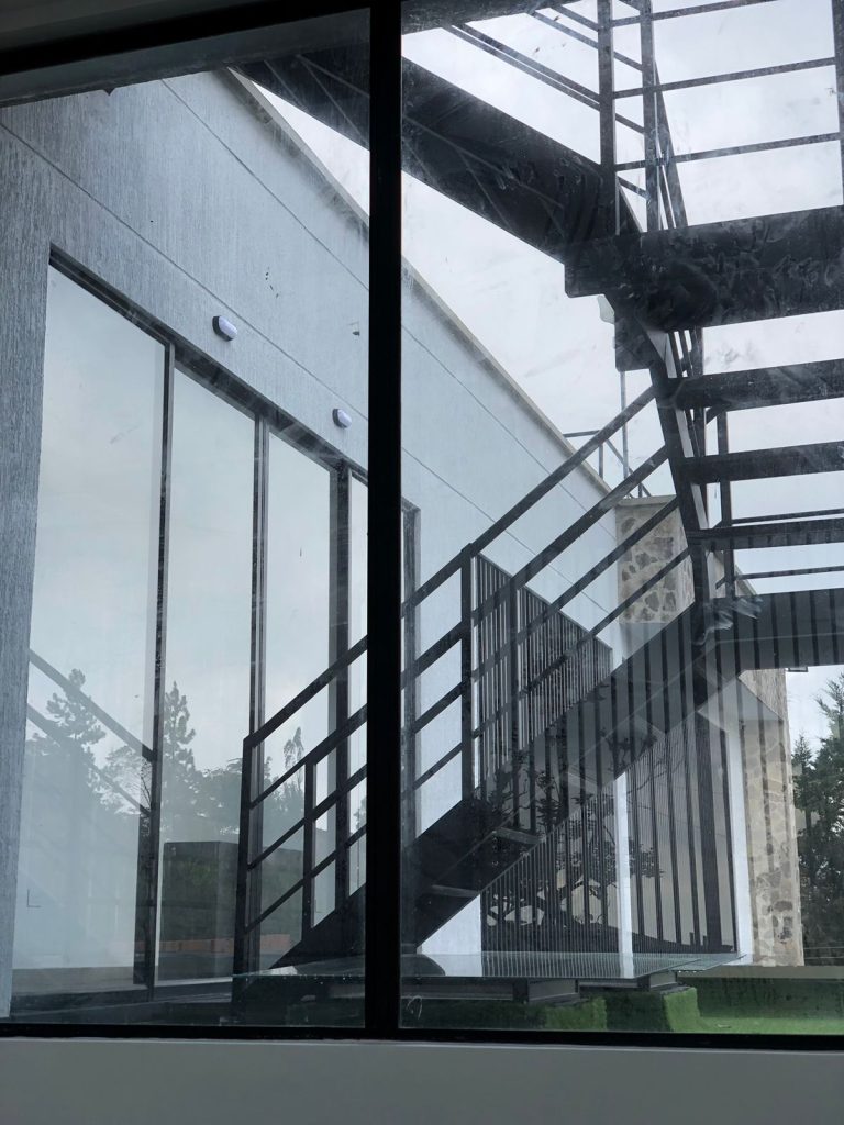 Escalera metálica exterior vista a través de ventanería