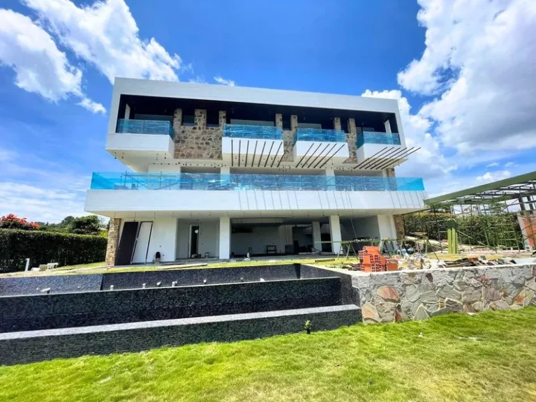 Casa de tres niveles con barandas en vidrio y ventanería en aluminio
