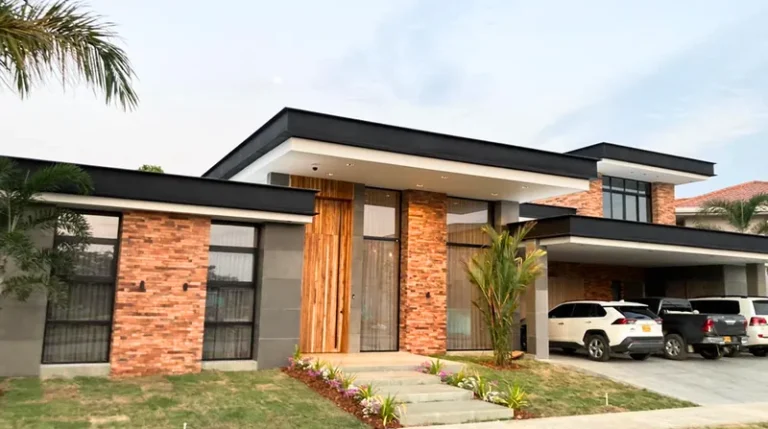 Fachada de casa con ladrillo y ventanas de aluminio negro instaladas por Metalorn