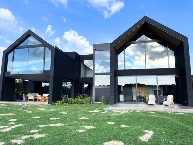 Casas de techo a dos aguas con fachadas en vidrio y aluminio negro