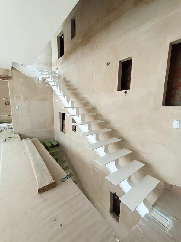 Escalera metálica con huellas blancas instalada en obra