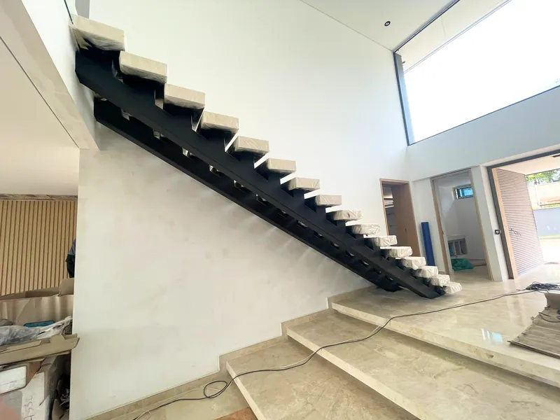 Escalera metálica negra con peldaños volados en vivienda