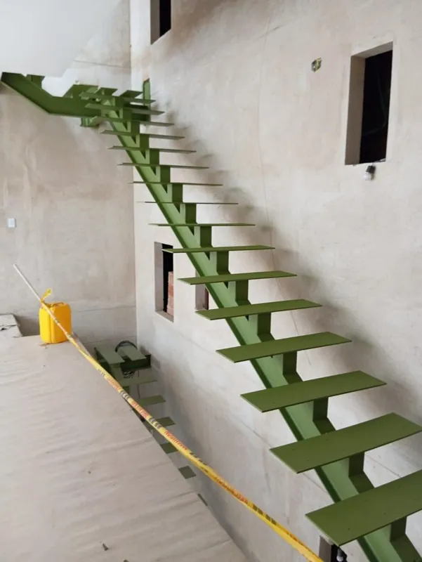 Escalera metálica de viga central en proceso de instalación en obra