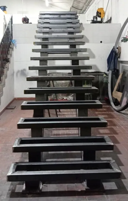 Escalera metálica de huellas rectangulares en el taller antes de su instalación