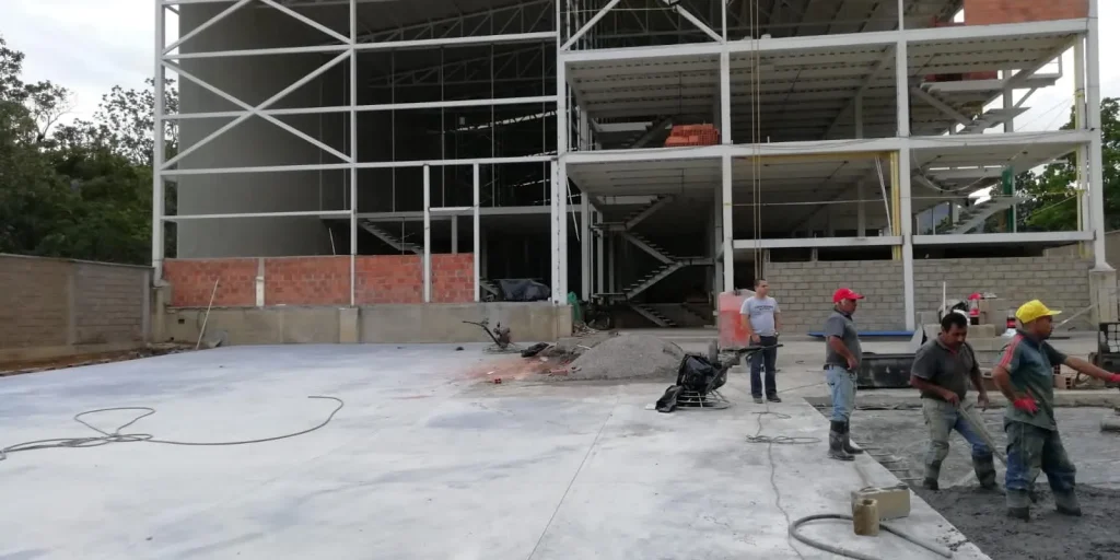 Estructura metálica de varios niveles en obra con trabajadores