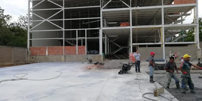 Estructura metálica de varios niveles en obra con trabajadores